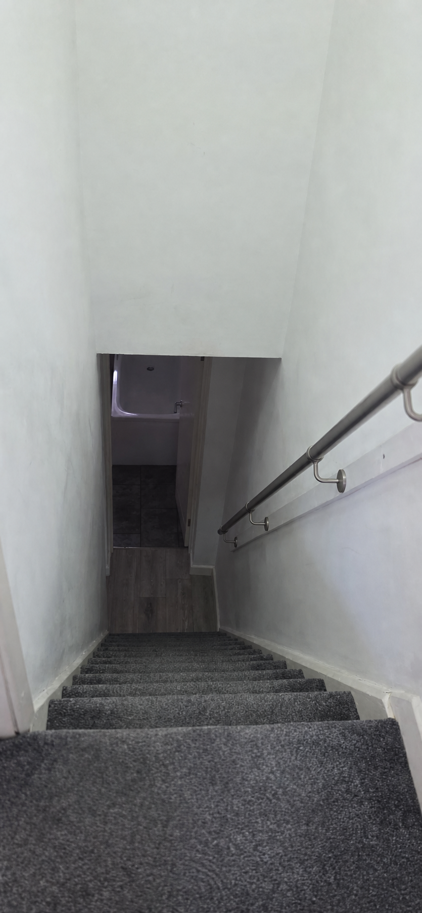 Completed carpeted staircase with handrail