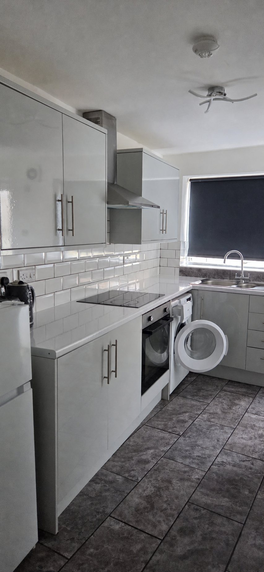 Completed fitted kitchen with tiled splashback and finished flooring