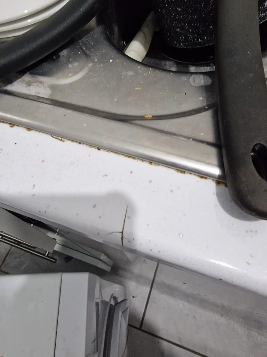 Main Street hob edge and adjacent worktop photographed after the tenancy, with debris and marks visible