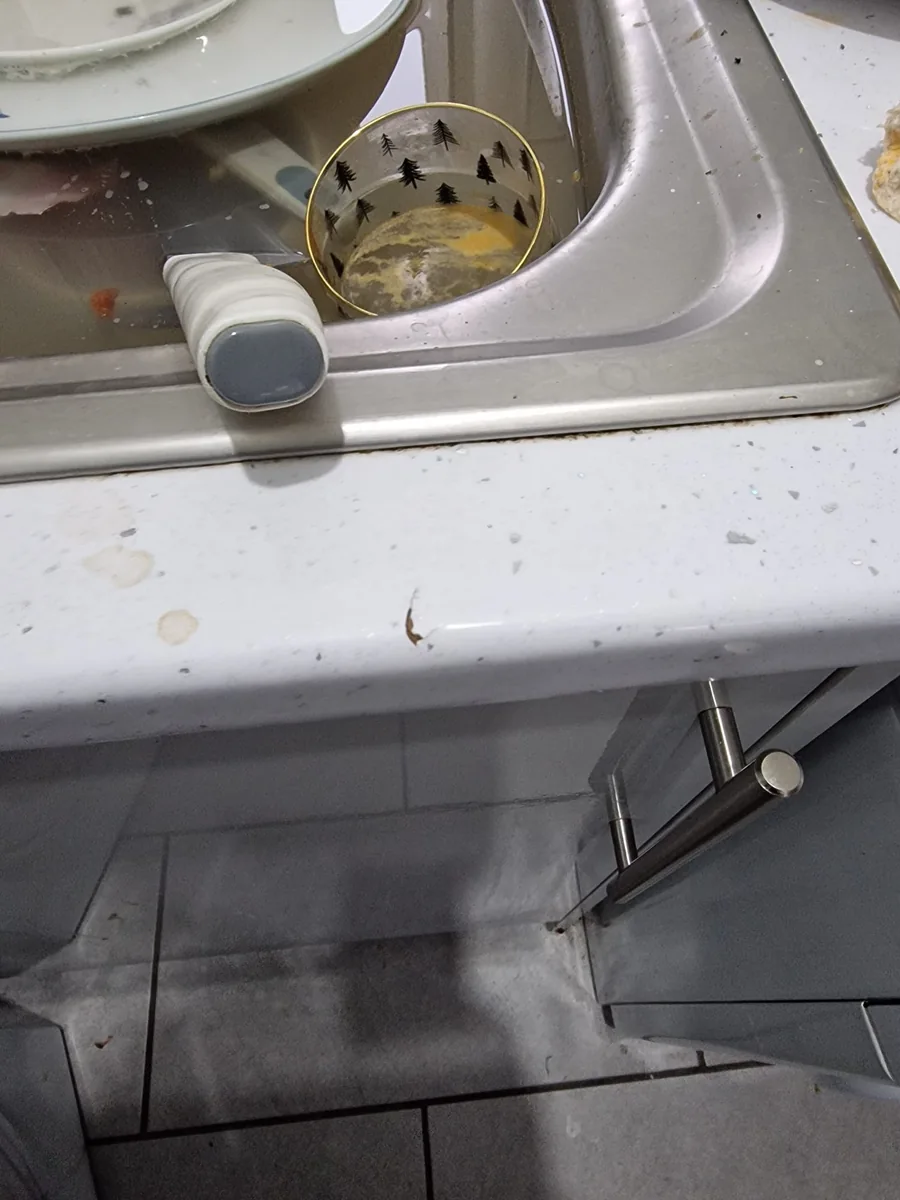 Main Street kitchen sink and worktop photographed after the tenancy, with items and residue visible